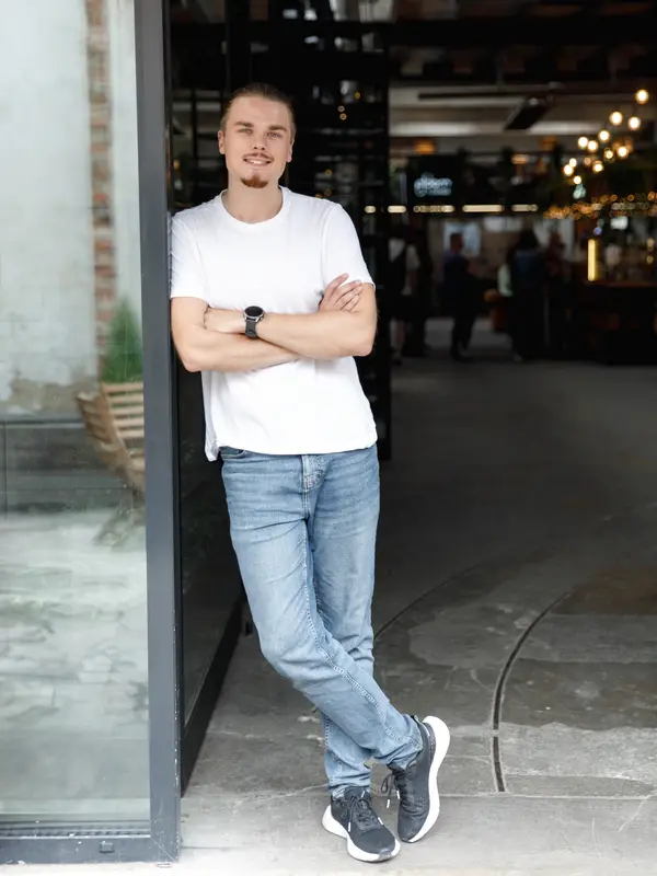 Egor Nefedov opřený v otevřených dveřích industriálního prostoru